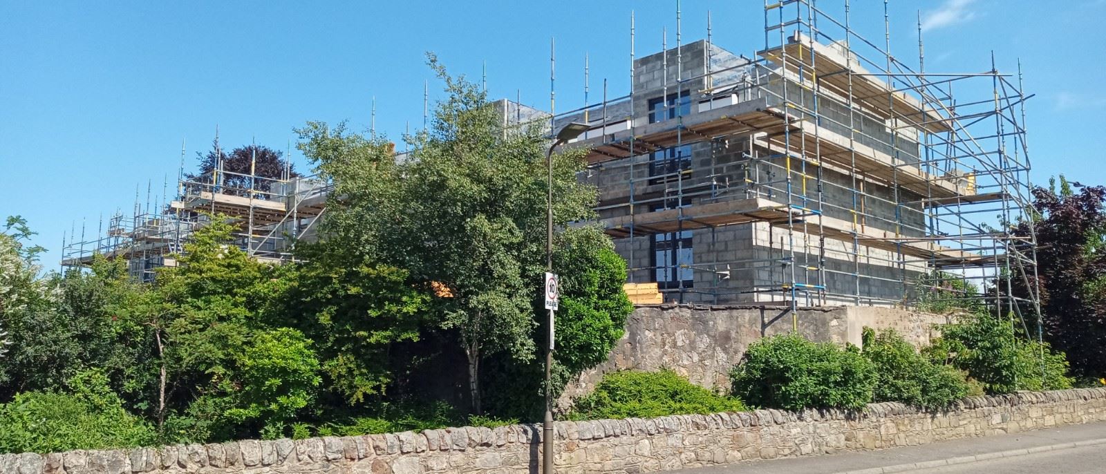 roughcast render applied to a residential building with scaffolding setup
