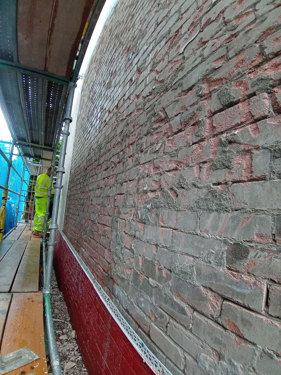 roughcast render repair on the side of the house with scaffolding