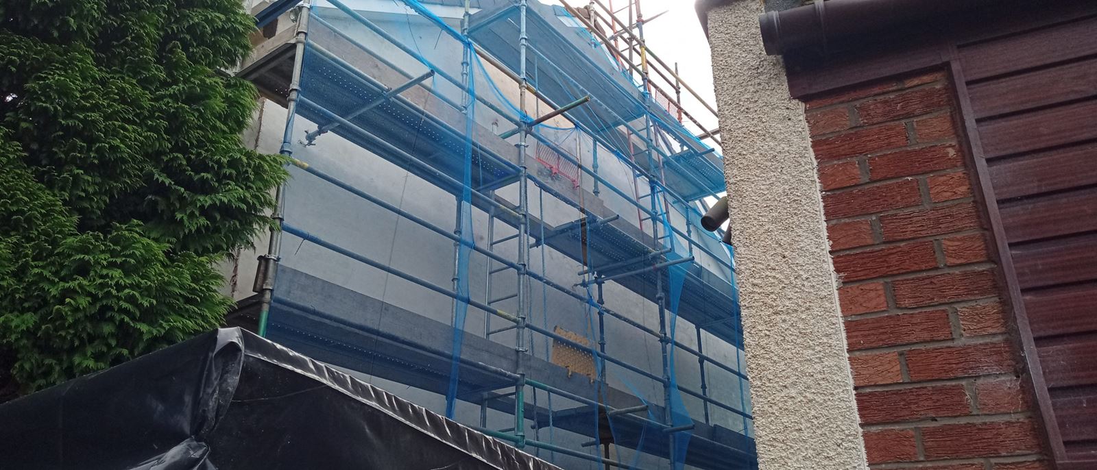 rendering Edinburgh applied to the exterior wall near scaffolding