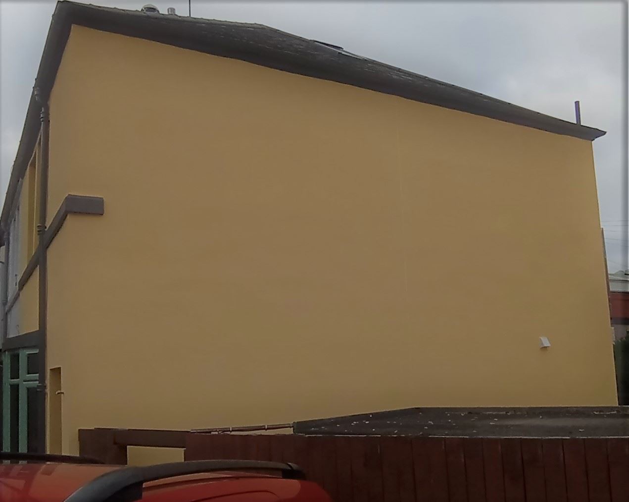 roughcast render repair on a building exterior with chimney
