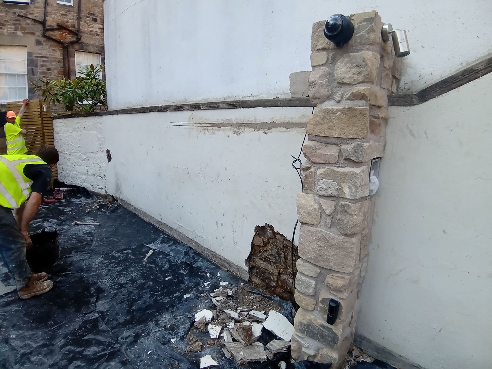 roughcast render repair on the exterior wall of a house with tools visible