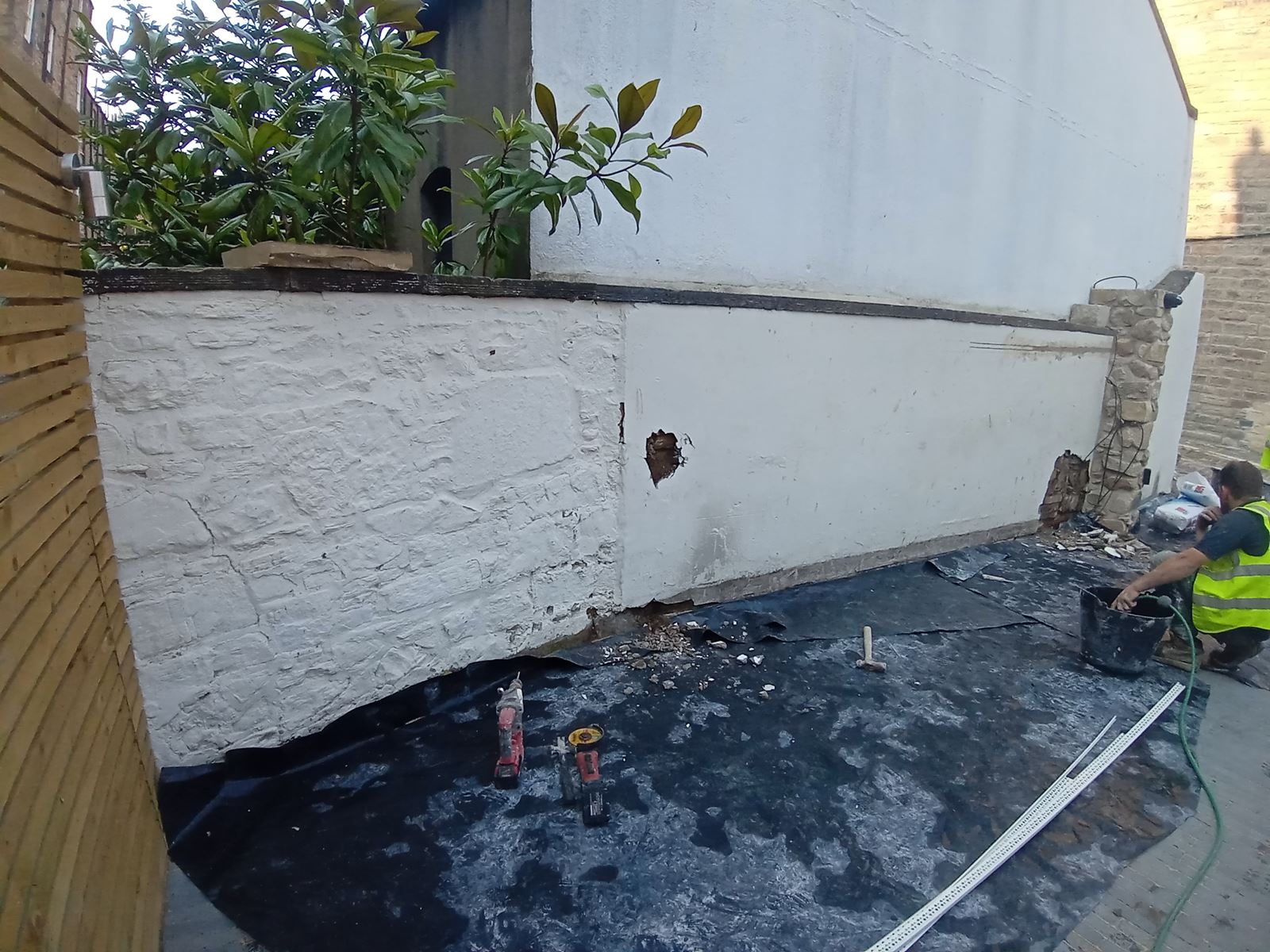 roughcast render repair being done on a wall near the ground level
