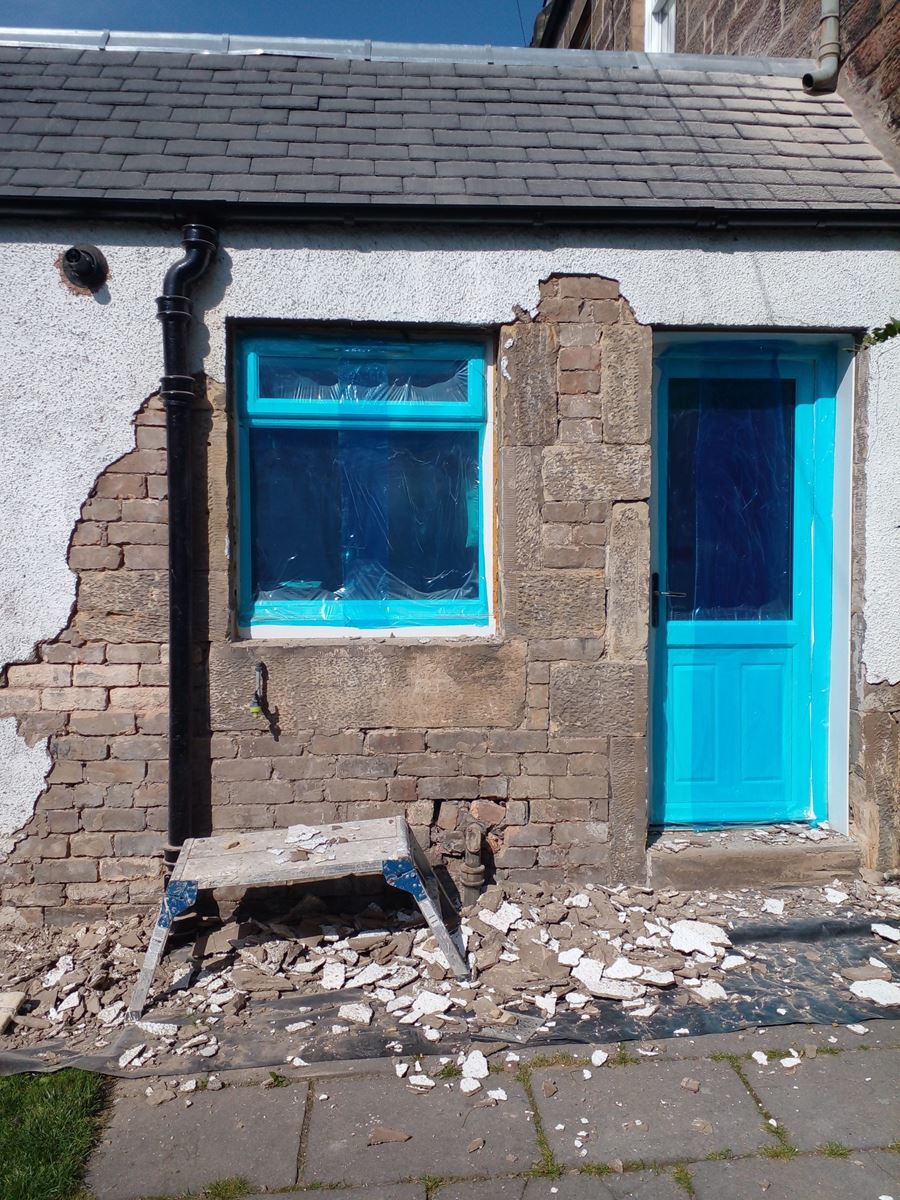 roughcast render repair on the exterior wall of a house