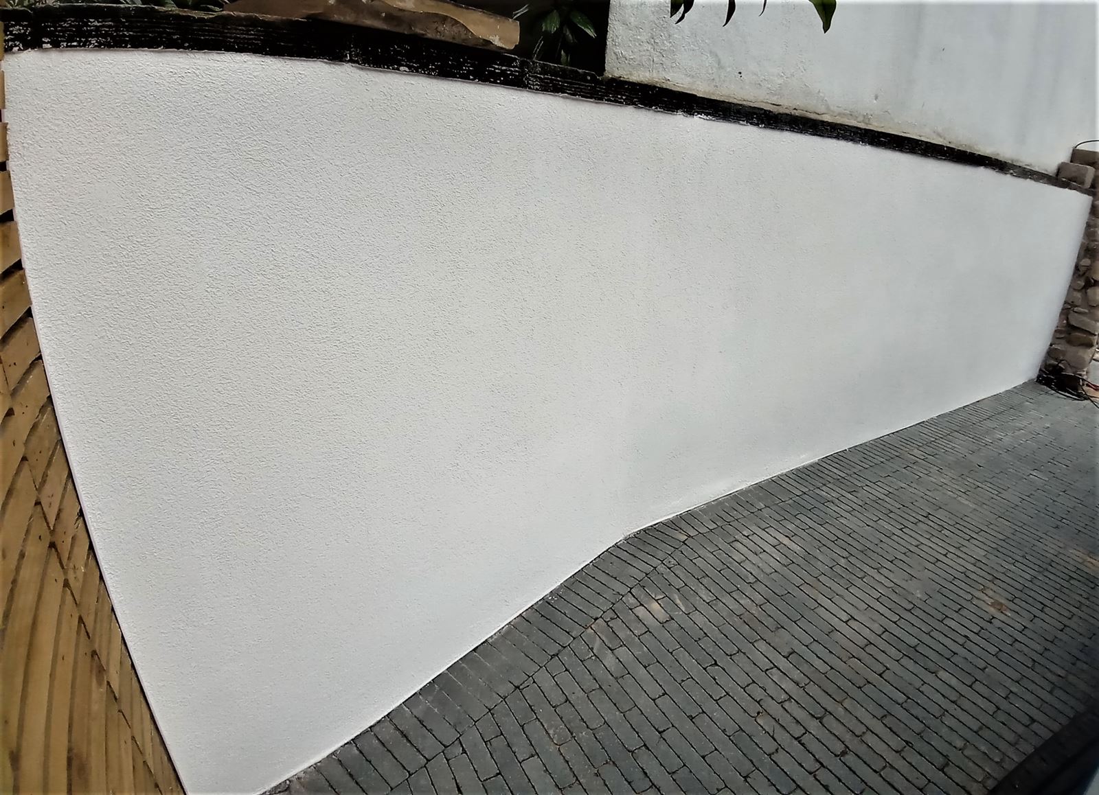 roughcast render Edinburgh on a house corner near a stone feature
