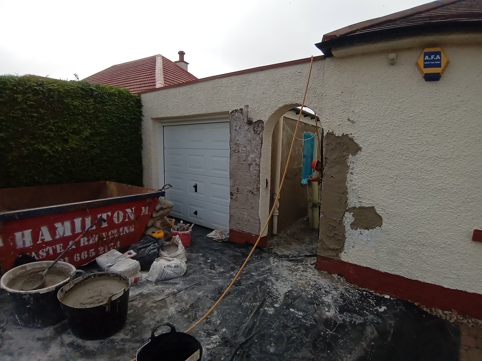 roughcast render repair on the exterior of a building near a window