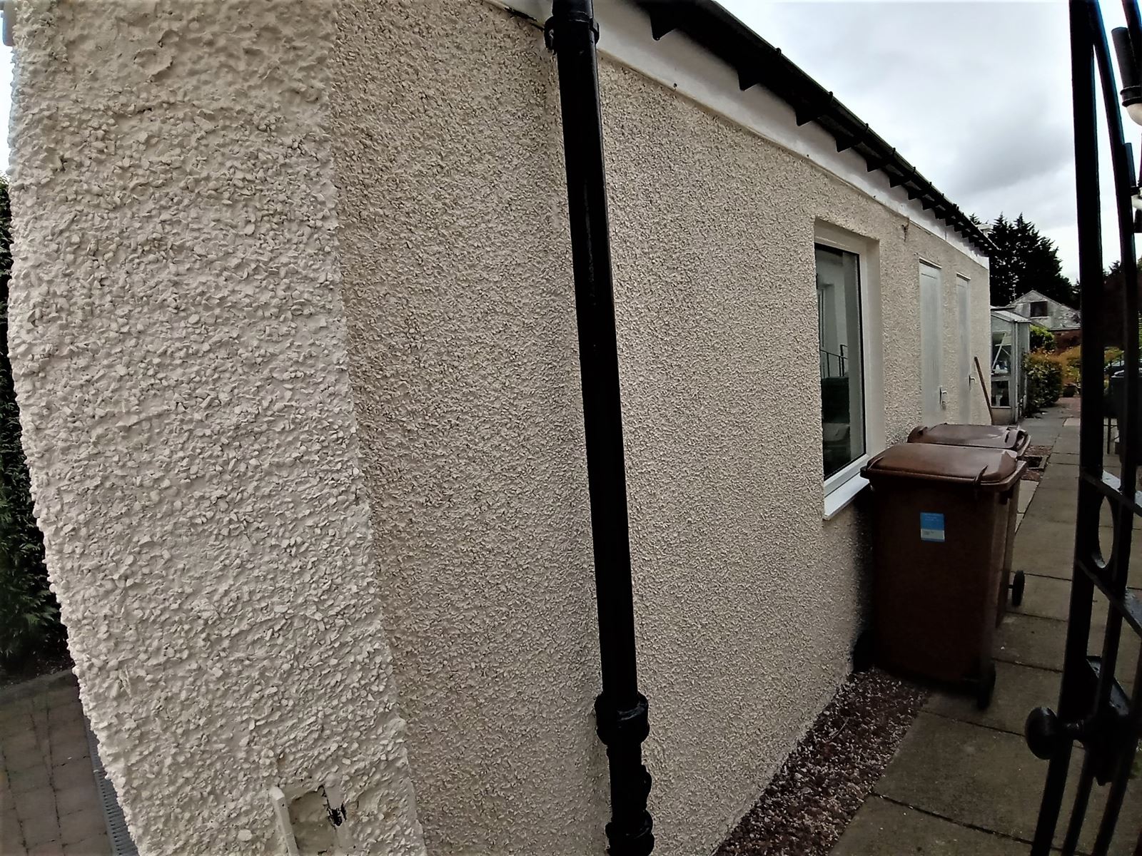 roughcast render Edinburgh on a wall with a stone feature and preparation work