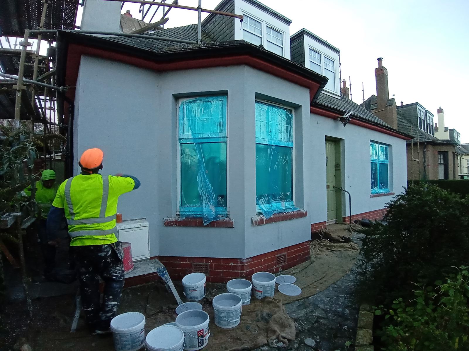 roughcasting Edinburgh in progress with a worker applying render
