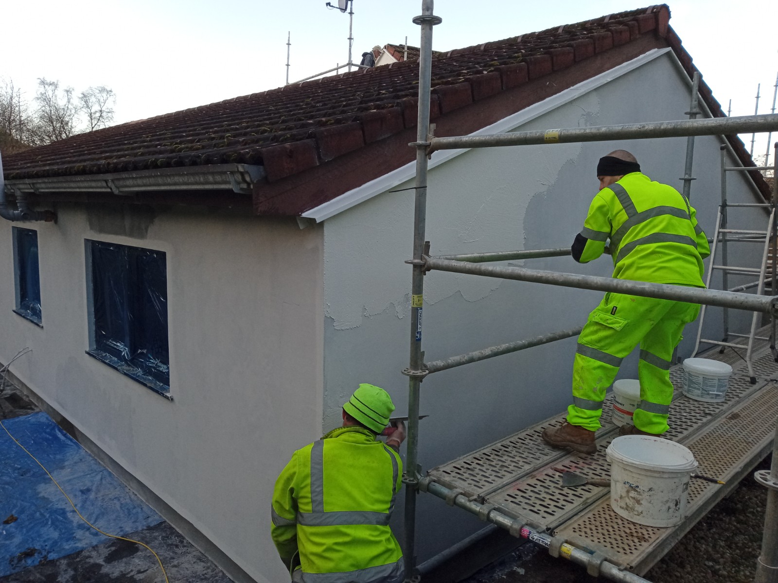 roughcast render repair process on the building's facade