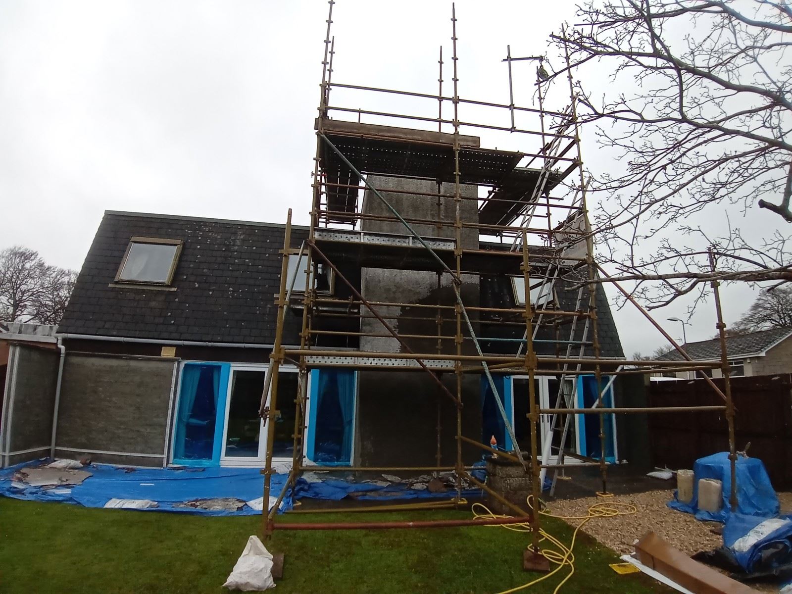scaffolded house during roughcast repair