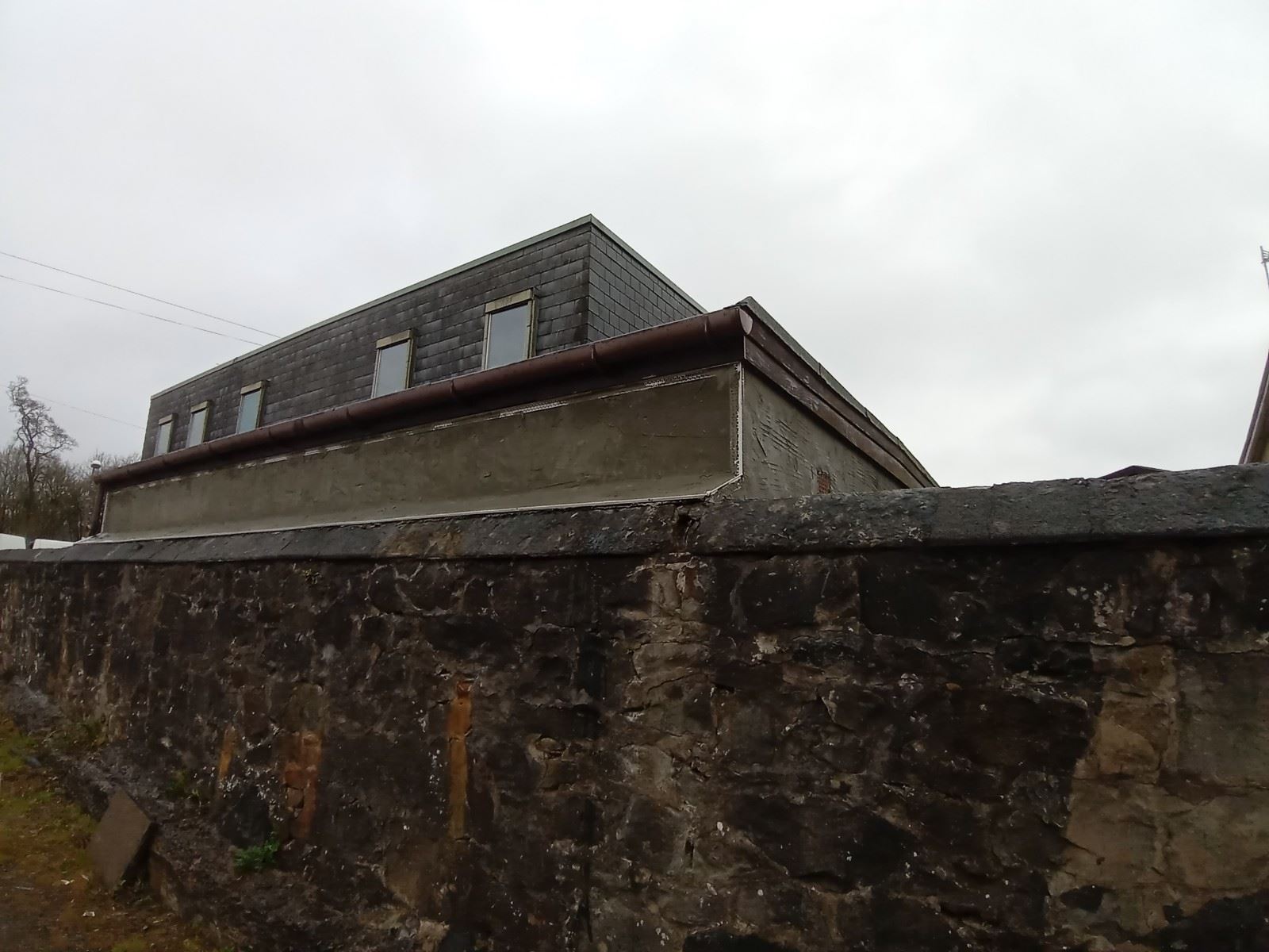 stone wall beside roughcast render edinburgh