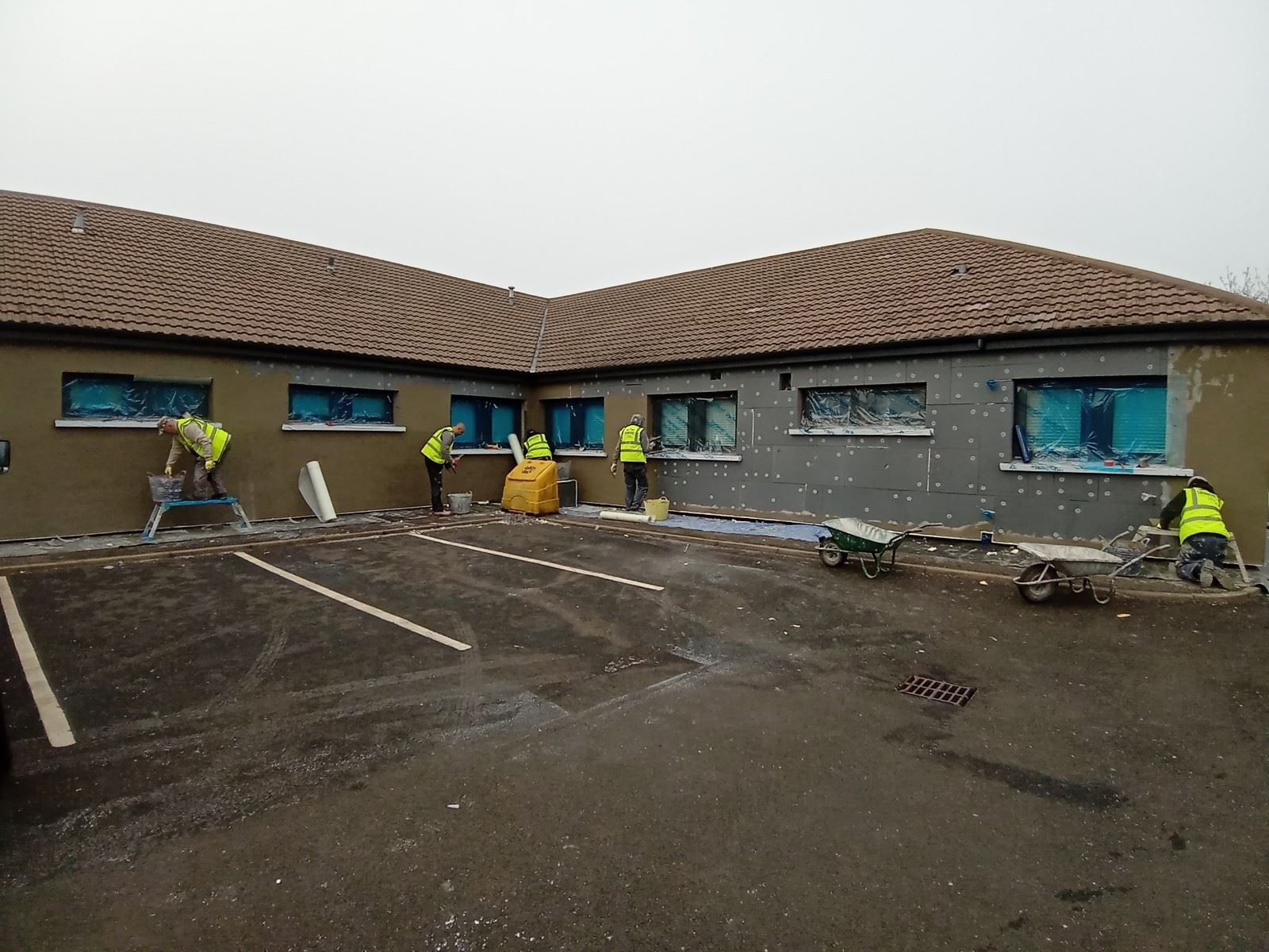 workers on site doing roughcast render repair