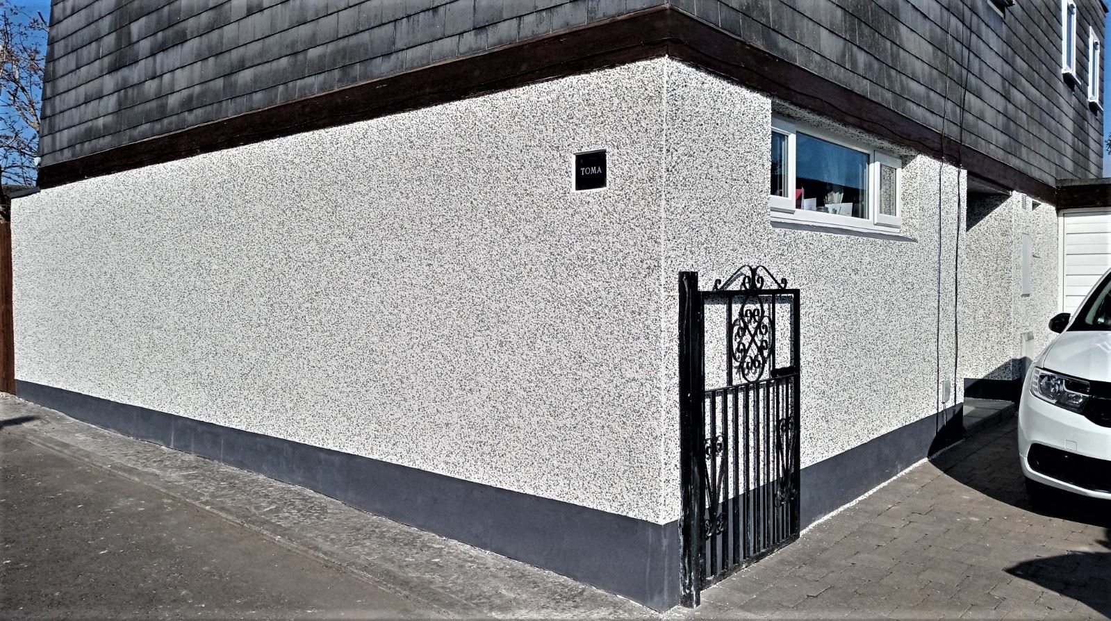 white wall and gate with roughcast repair