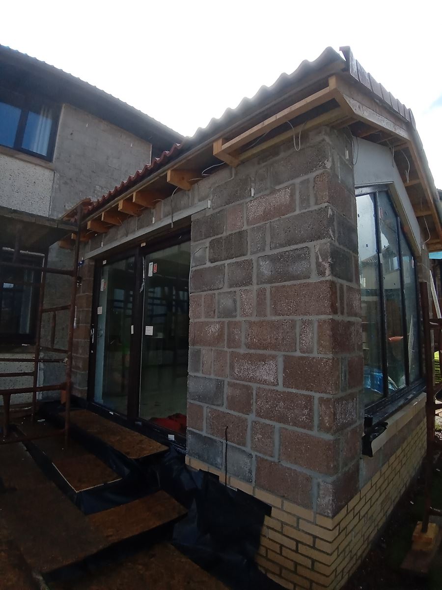 roughcast render repair on brick wall extension undergoing renovation