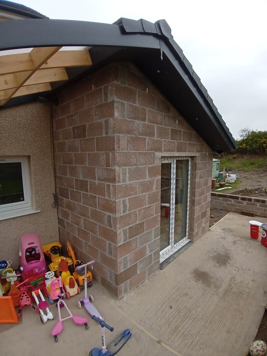 roughcast render repair on side extension with toys beside door