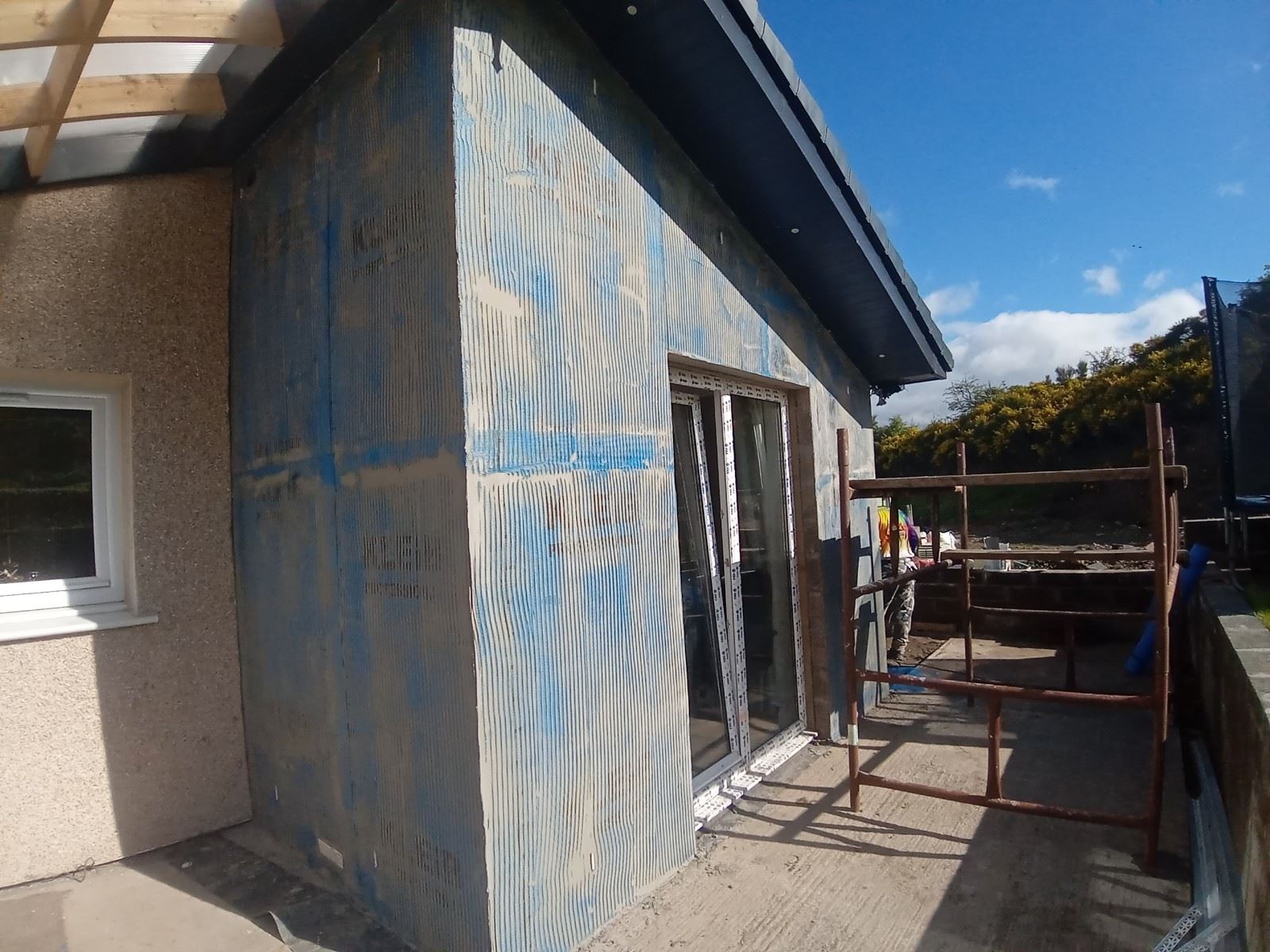 roughcasting Edinburgh on extension wall with blue protective film