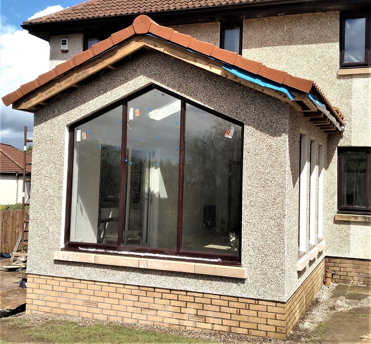 roughcast repair on angled bay window wall with pebble dash