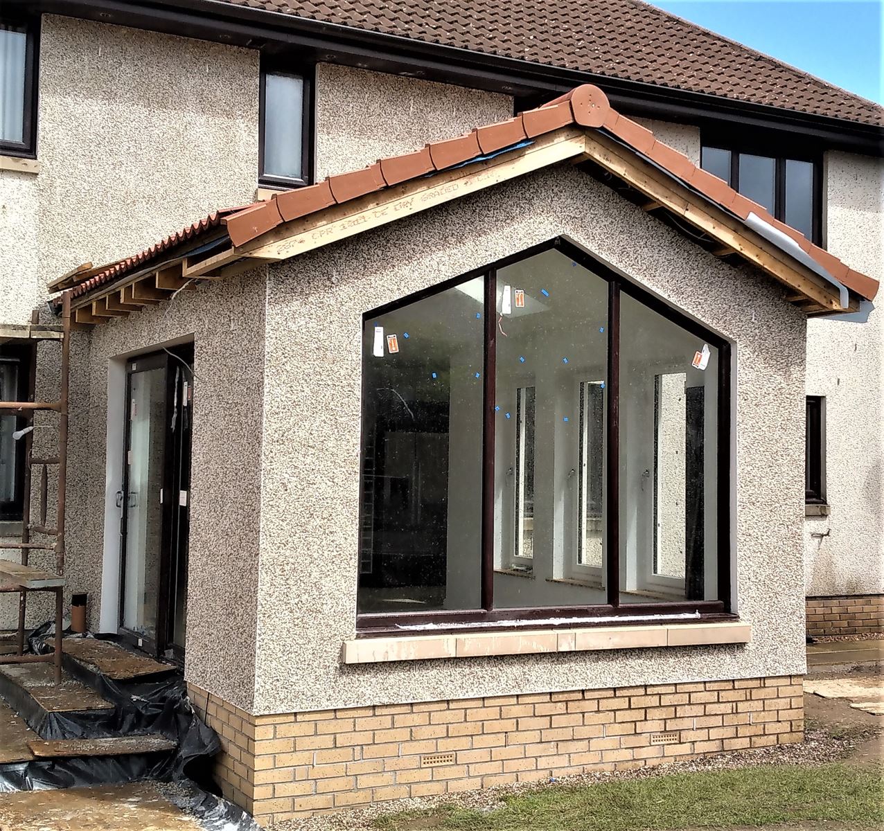 roughcast render repair on front-facing bay extension wall