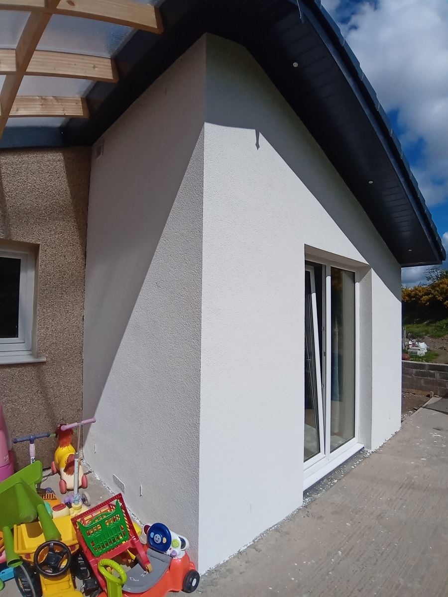 roughcast render repair on white corner wall with patio doors