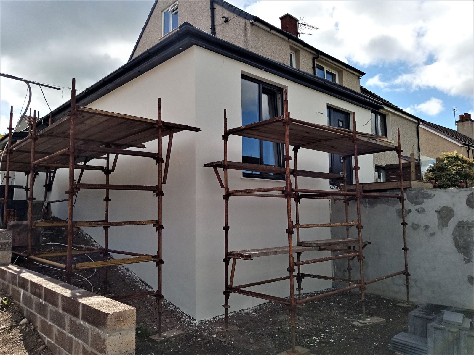 roughcasting Edinburgh on fresh white extension wall with scaffolding