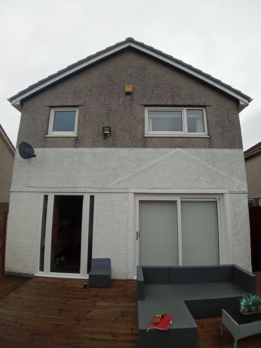 roughcast repair on front house wall with white door and windows