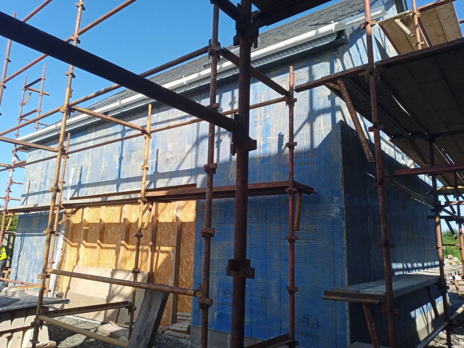 roughcast repair on wall section with protective timber enclosure