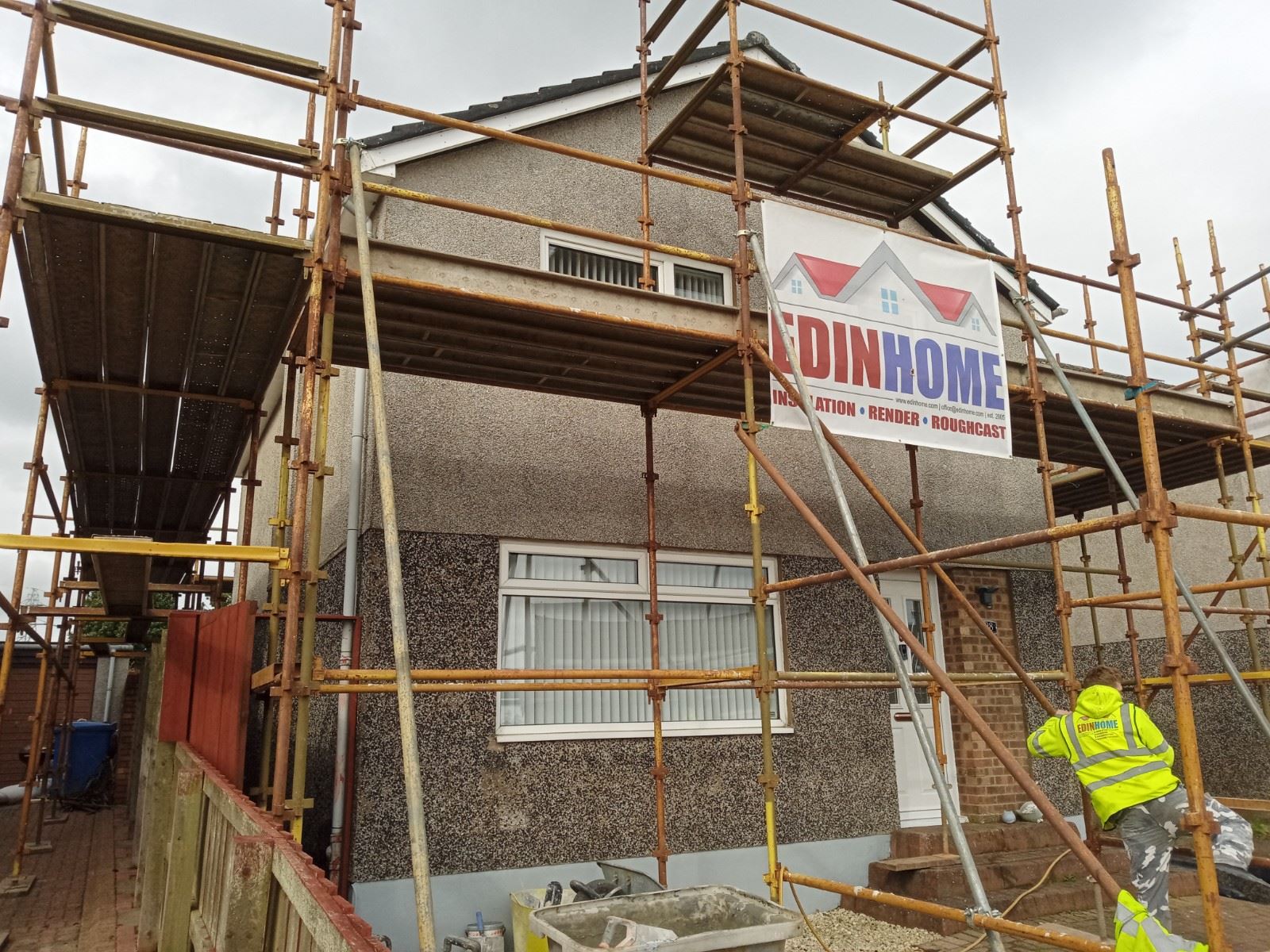 roughcast render repair on rear wall with scaffold and workers