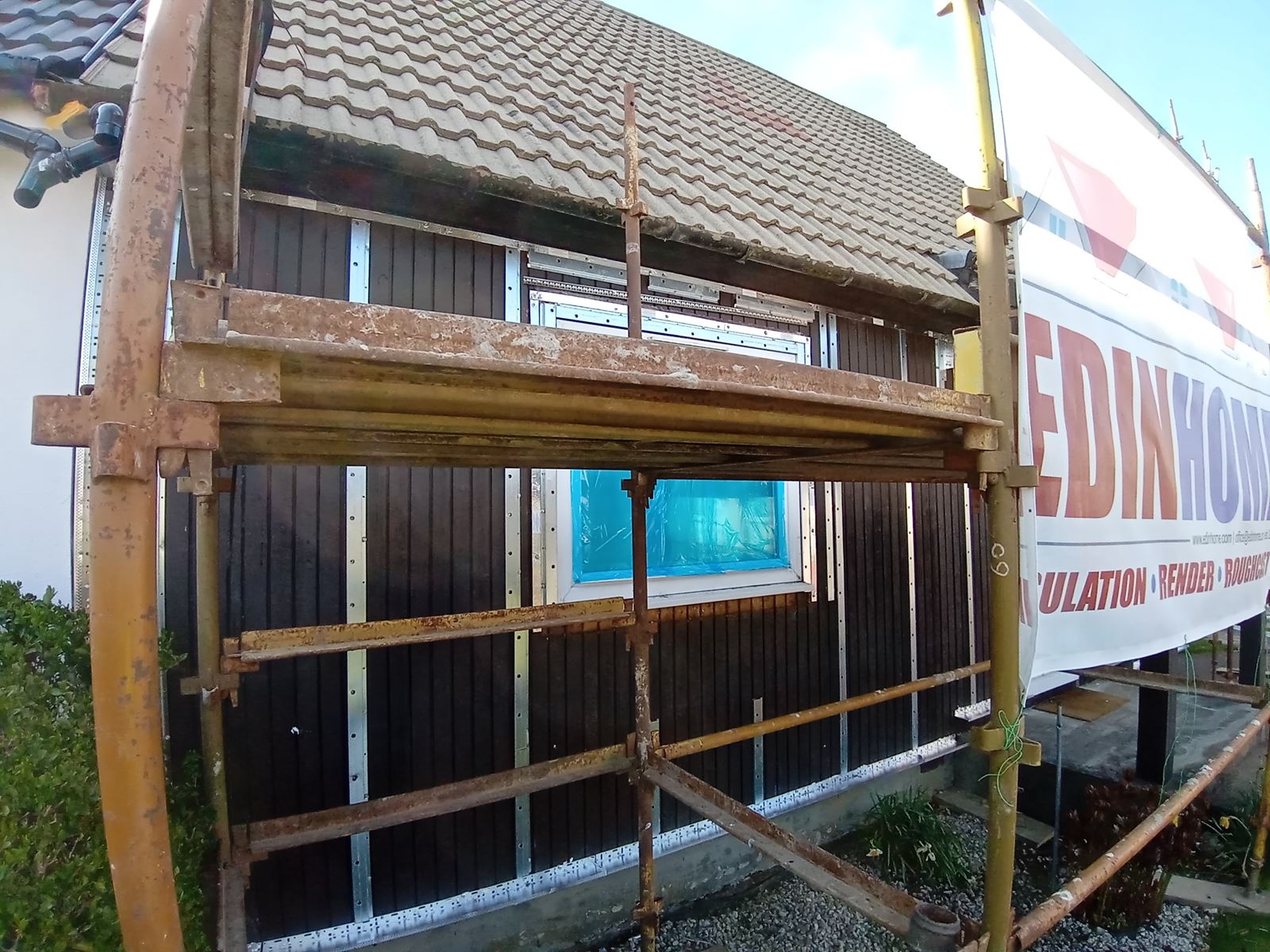 roughcast repair on wall insulation boards under scaffolding