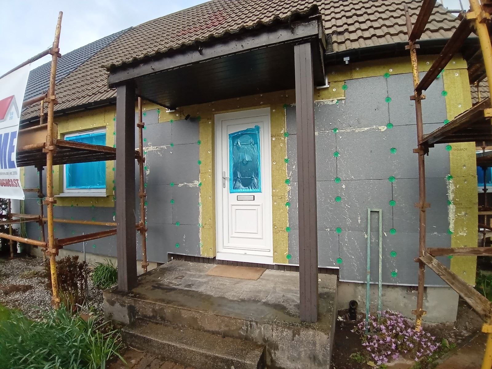 roughcast render repair on front porch wall with blue door protection