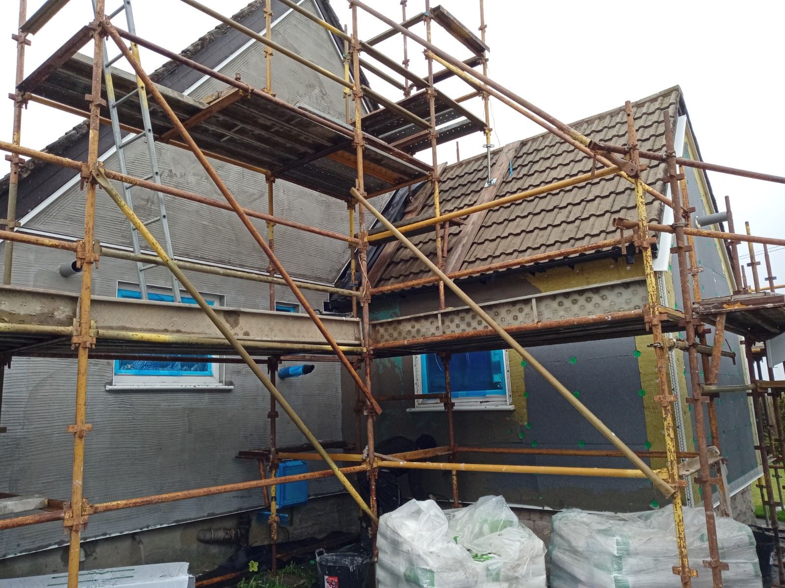 Rendering Edinburgh under scaffold on house with multiple windows covered