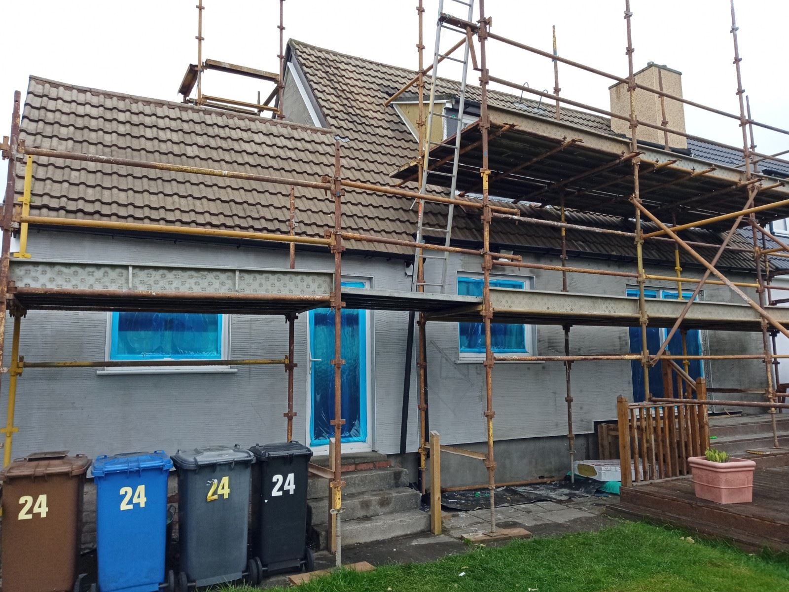 roughcast render repair on rear wall of bungalow under scaffold