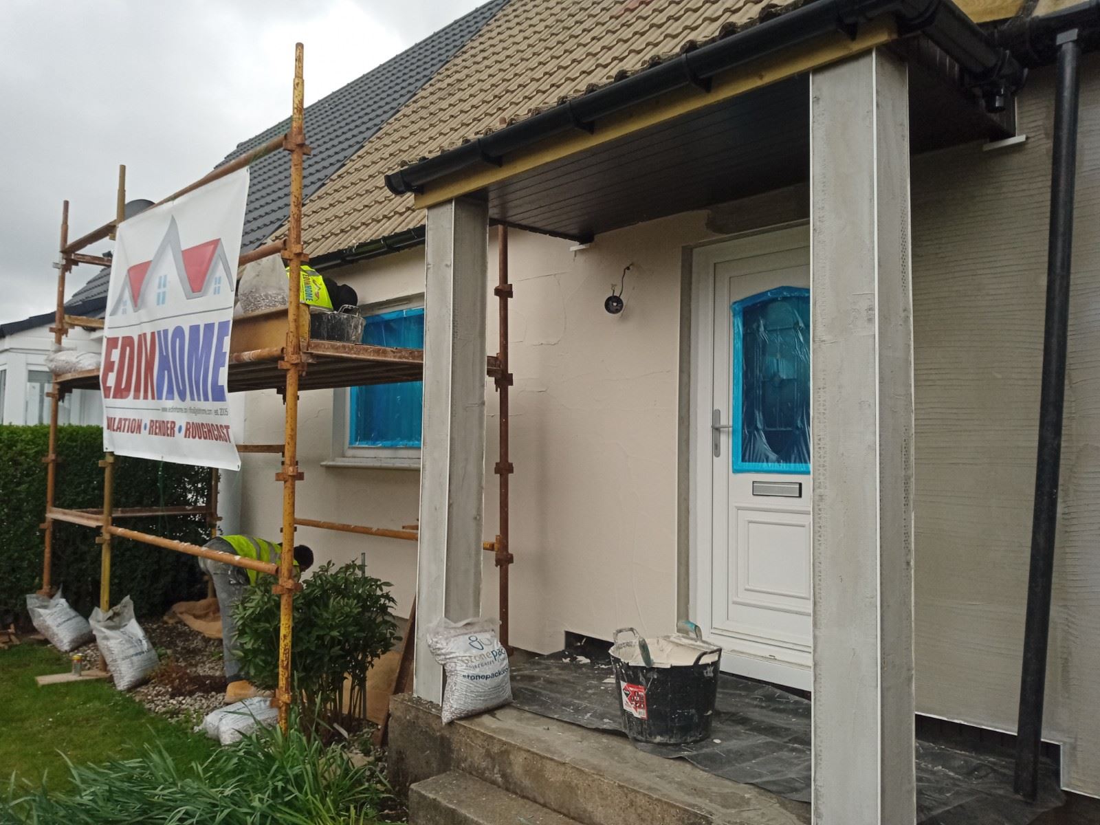 roughcast render Edinburgh on front porch with white door and scaffolding