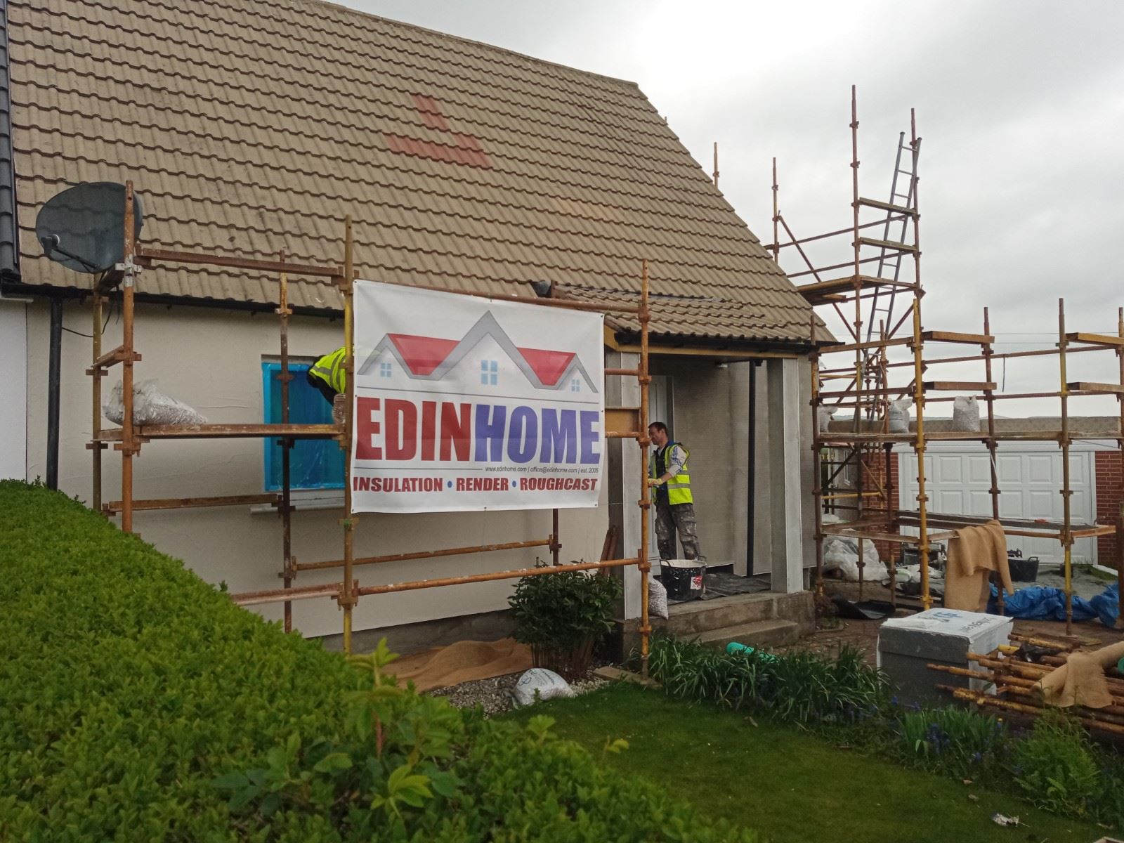 roughcasting Edinburgh on house wall under scaffolding with banner
