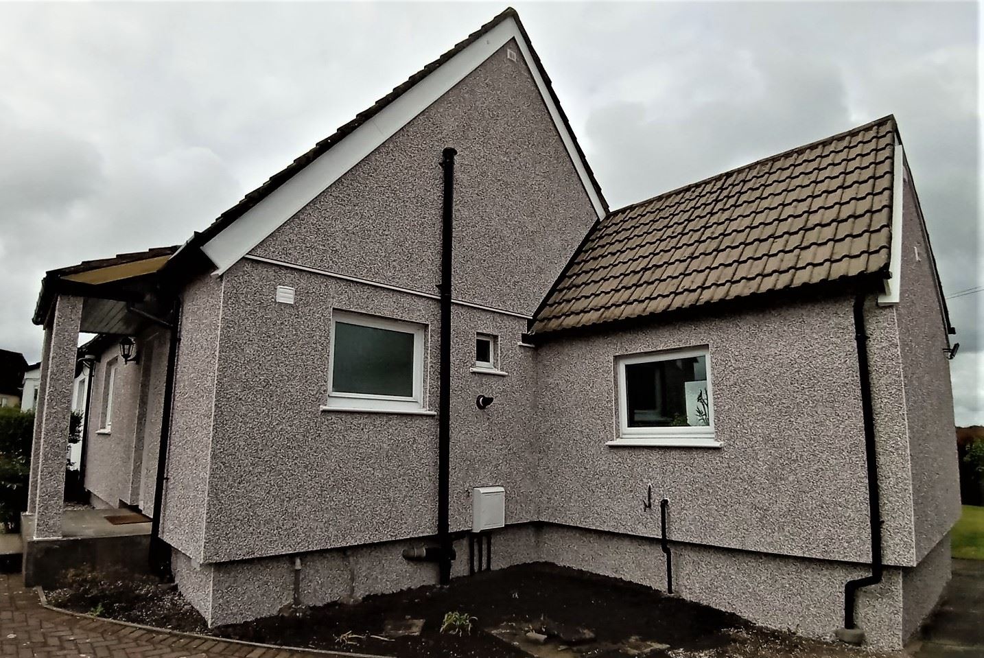 roughcaster Edinburgh working on side wall of extension with small window