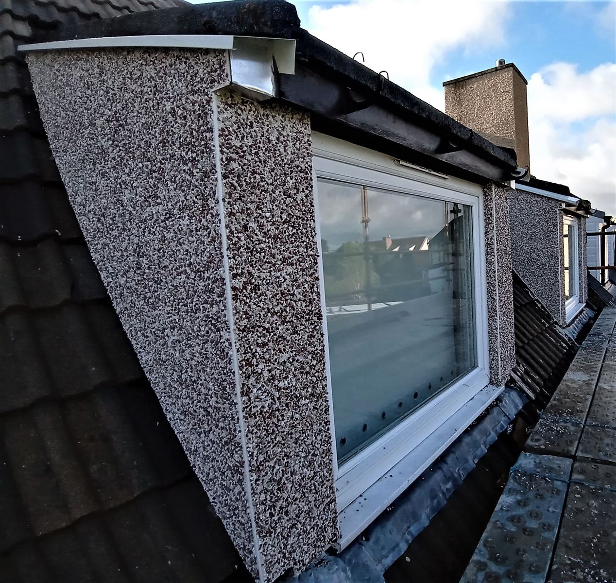 house rendering Edinburgh on rooftop window with pebble dash finish
