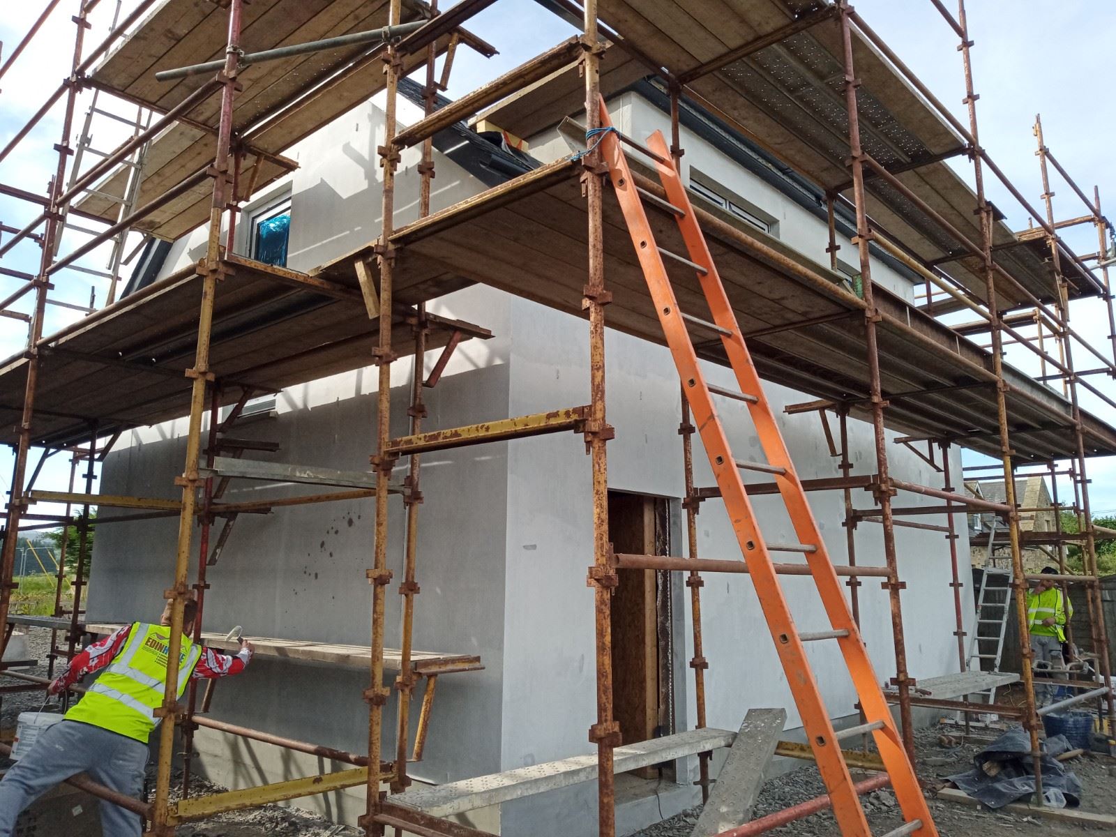 roughcasting Edinburgh on house wall under scaffolding with ladder