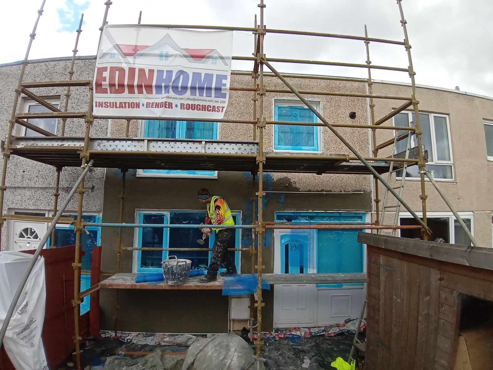 Rendering Edinburgh on two-storey façade with blue protective window covers