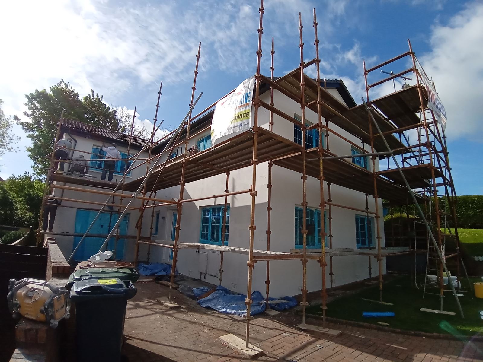 roughcast render repair on front two-storey house with scaffolding