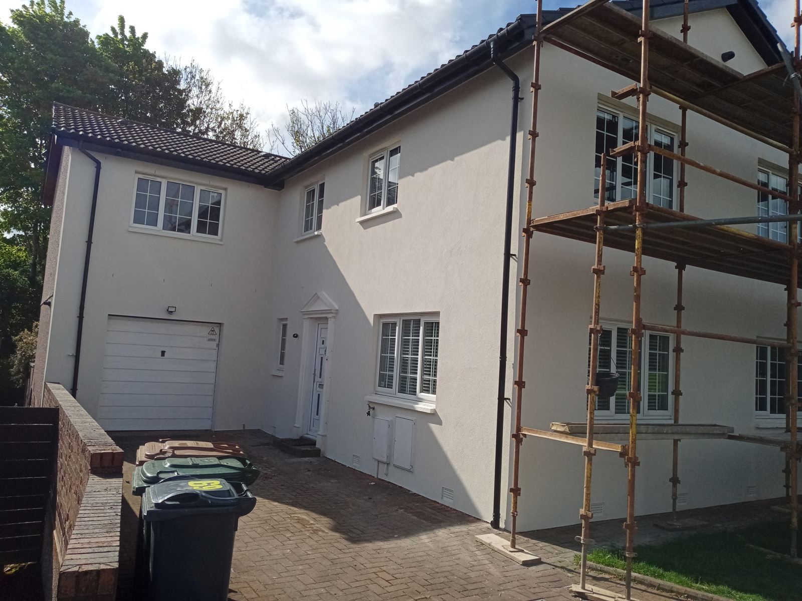 roughcast render repair on property wall with garage and scaffolding