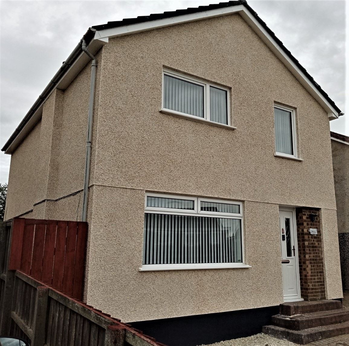 roughcasting Edinburgh on gable wall of detached house with white trim