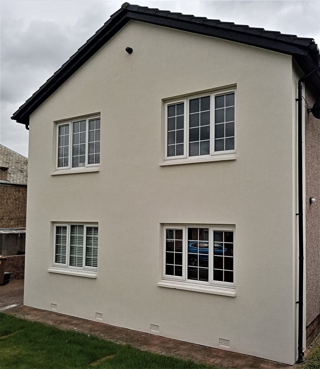 roughcasting Edinburgh on front gable wall with two white-framed windows