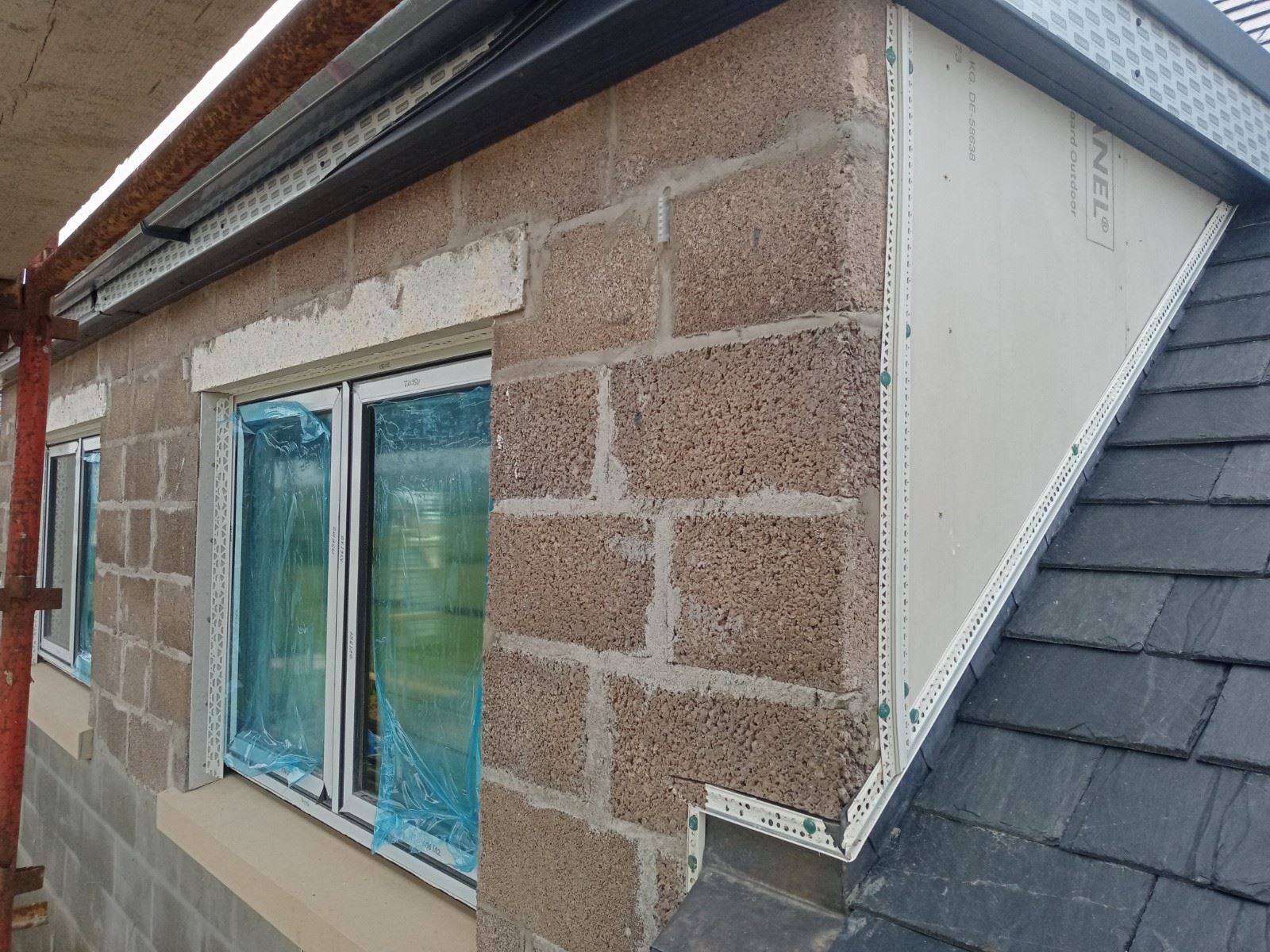 roughcast repair on wall with exposed brick and insulation detail