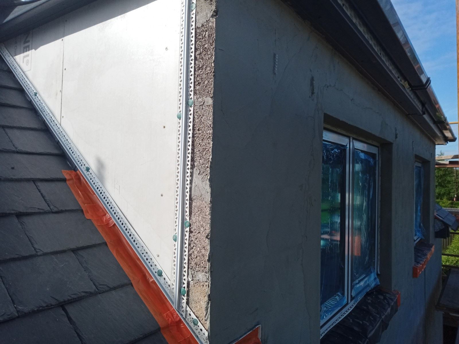 roughcast render repair on corner wall with visible insulation joints