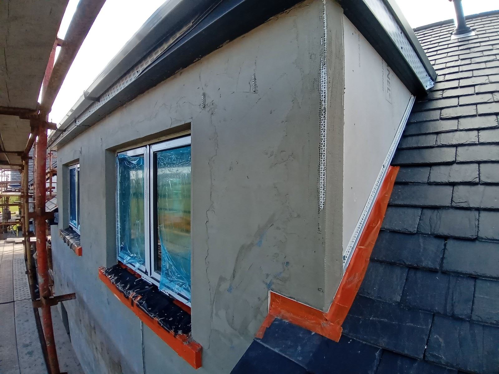 roughcaster Edinburgh working on grey façade around window