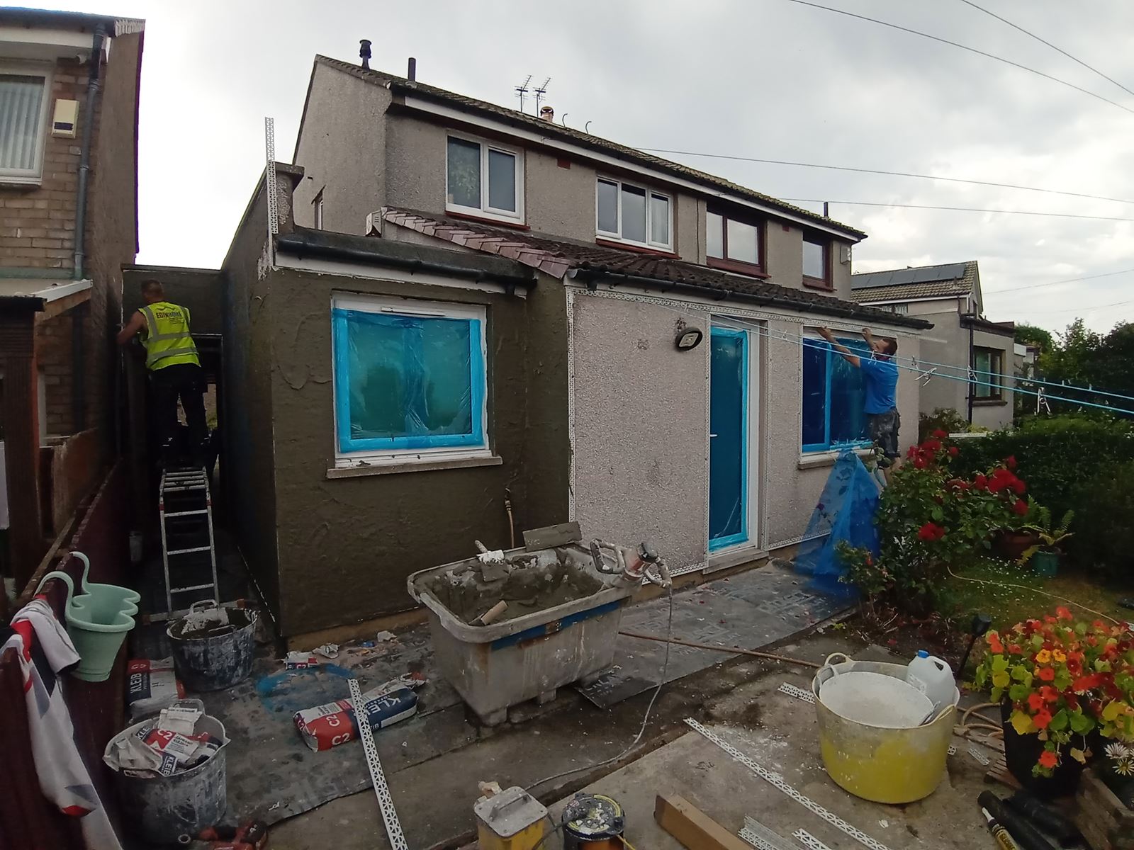 roughcast repair applied by worker on small house extension