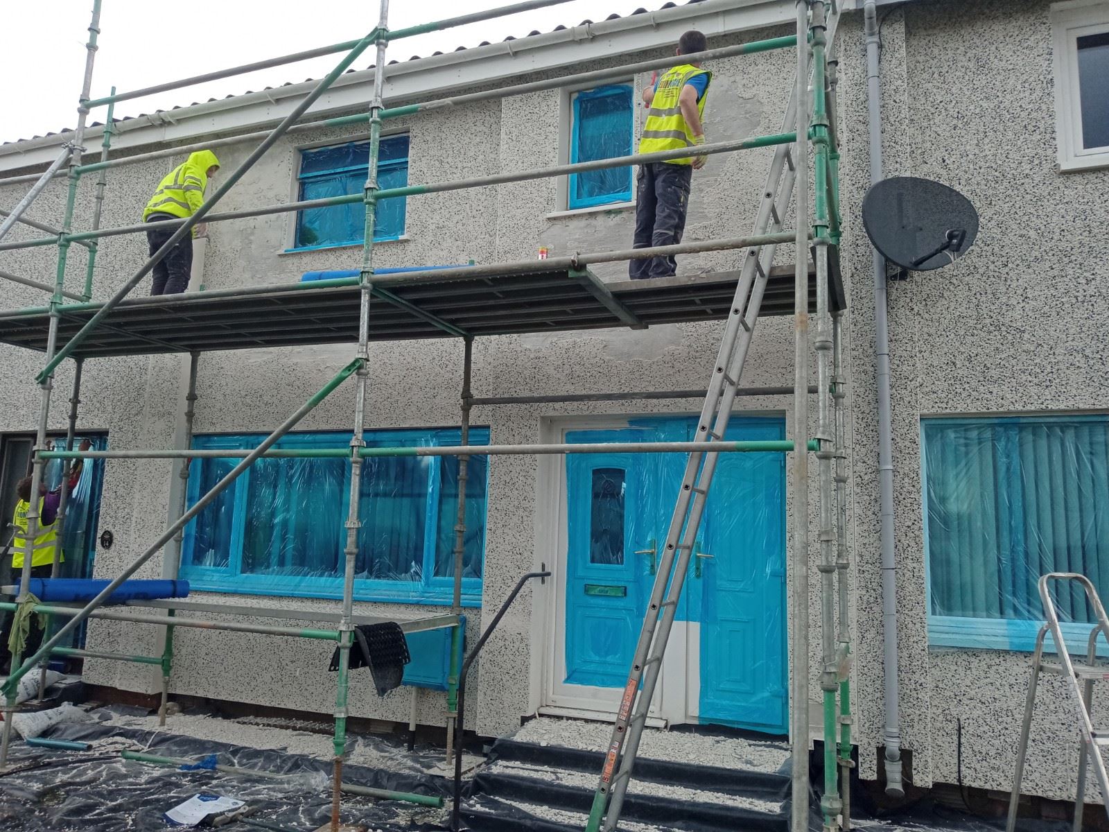 roughcaster Edinburgh working on upper scaffolded wall section