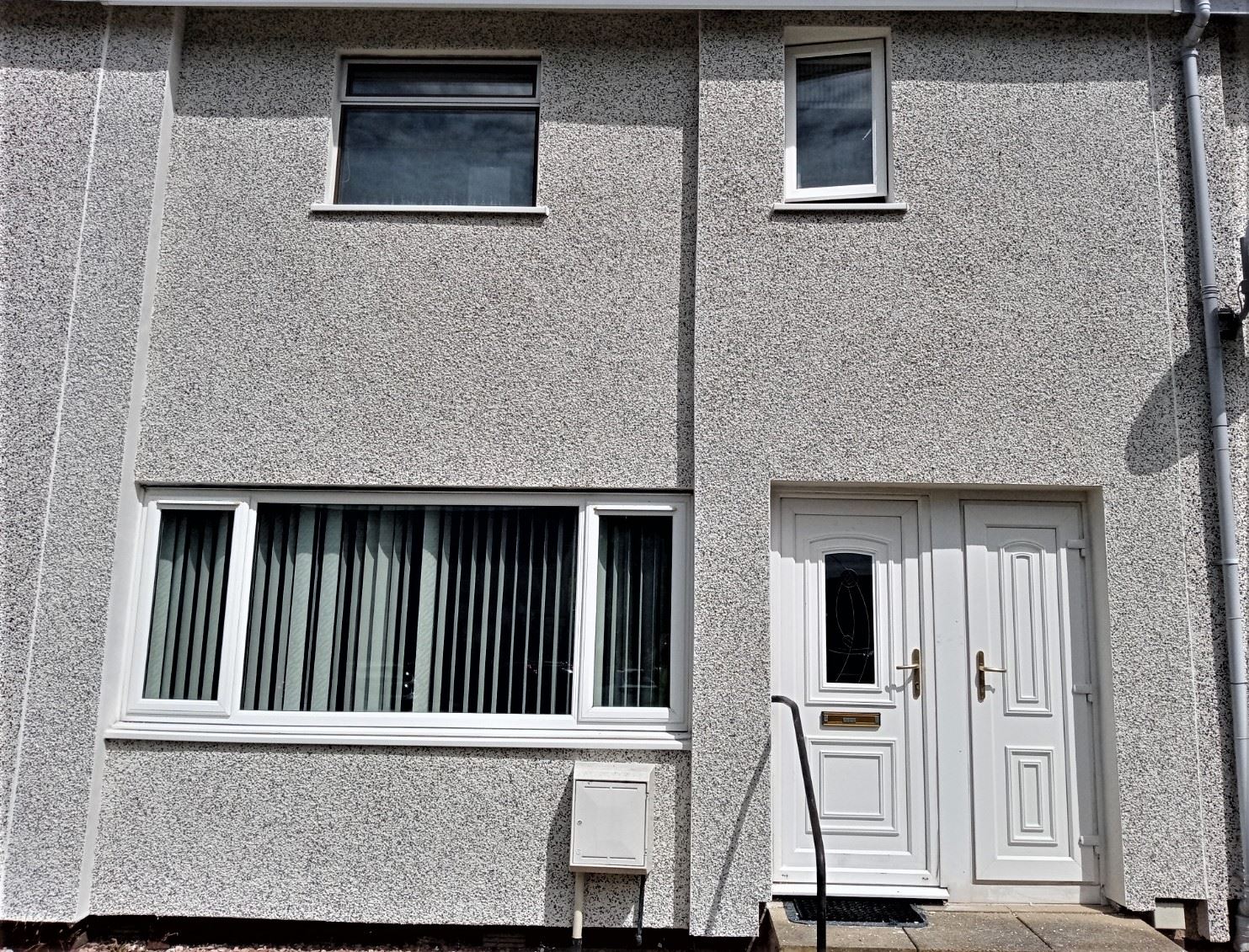 roughcasting Edinburgh on front façade with white door and window