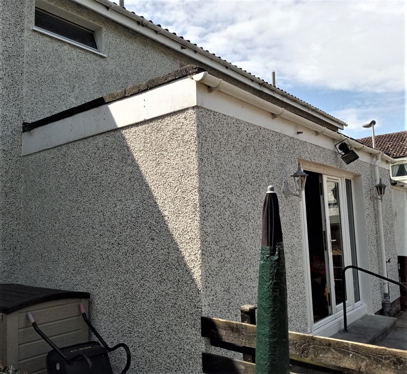 roughcast render repair on side extension with pebble dash finish