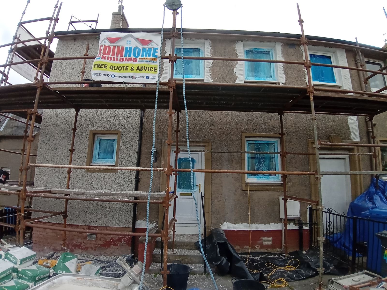 roughcaster Edinburgh repairing upper front façade under scaffold