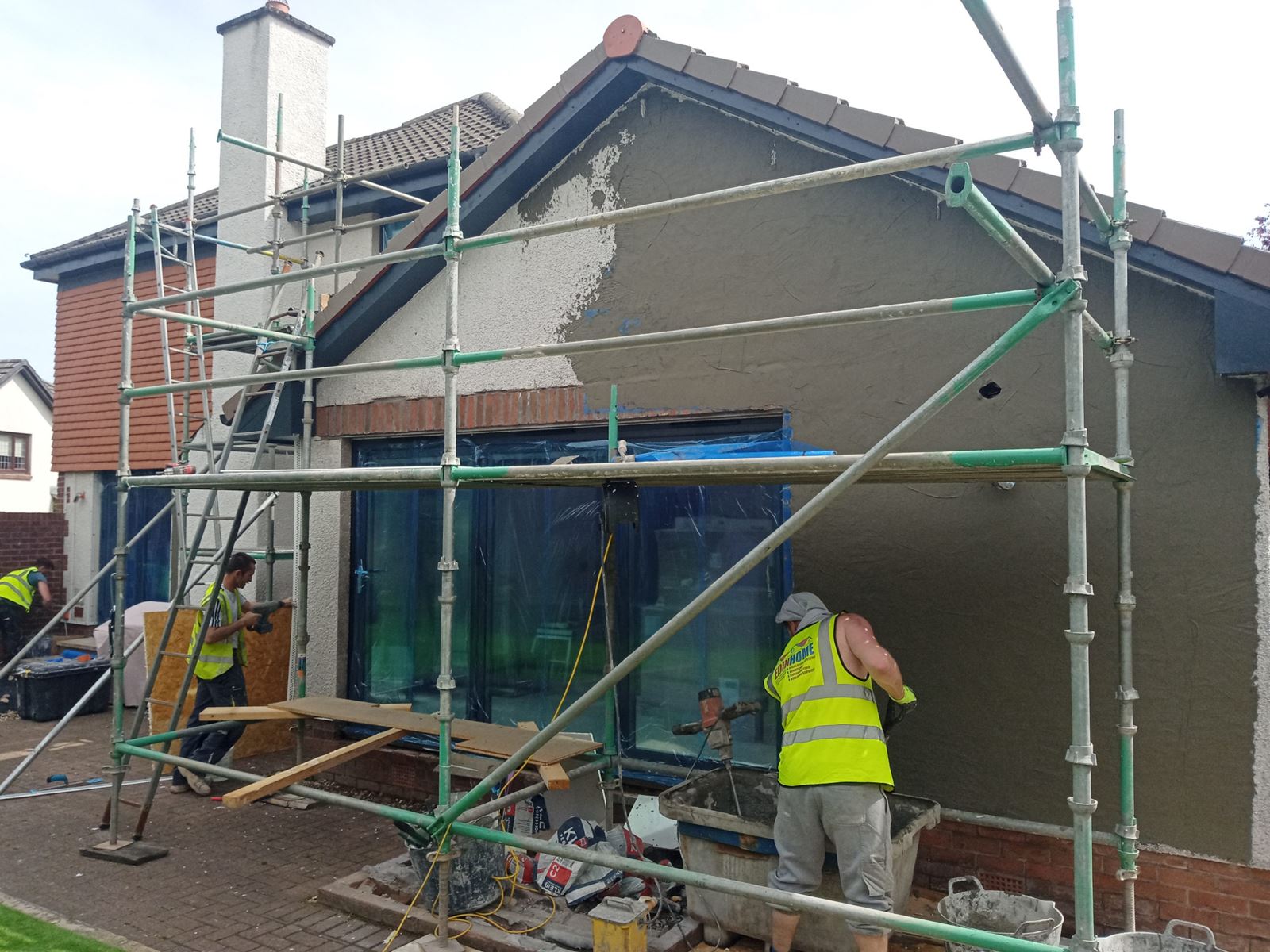 roughcast render repair on wall during scaffolded renovation