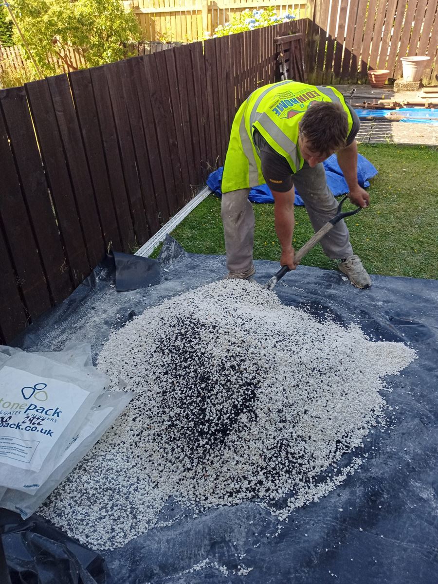 roughcast render repair with worker mixing stone aggregate